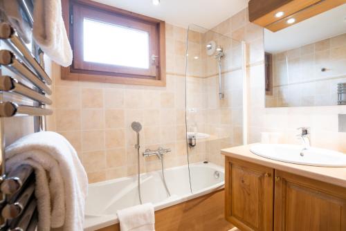 a bathroom with a tub and a sink and a shower at La Ferme Du Lac in Thyez