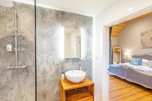 a bathroom with a sink and a shower and a bed at Thistle Lodge 20 with Hot Tub in Belladrum
