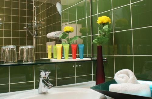 uma casa de banho com um lavatório com um vaso com flores amarelas em Sporthotel Xander em Leutasch