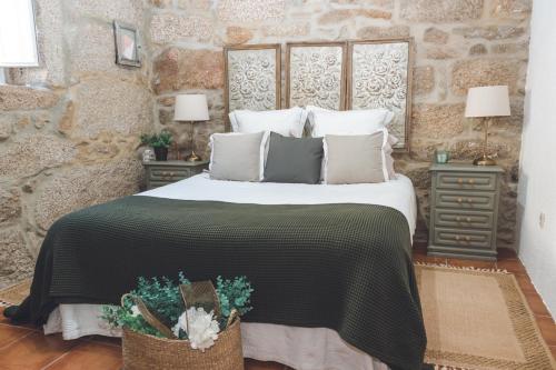 a bedroom with a large bed and two night stands at Casa da Nogueira in Arcos