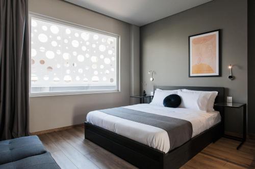 ein Schlafzimmer mit einem Bett und einem großen Fenster in der Unterkunft WYZ Athens Apartments by UPSTREET in Athen