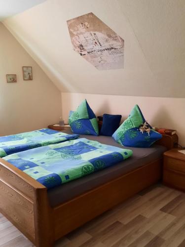 a bedroom with a bed with blue and green pillows at Ferienwohnung am Schloss in Reuterstadt Stavenhagen