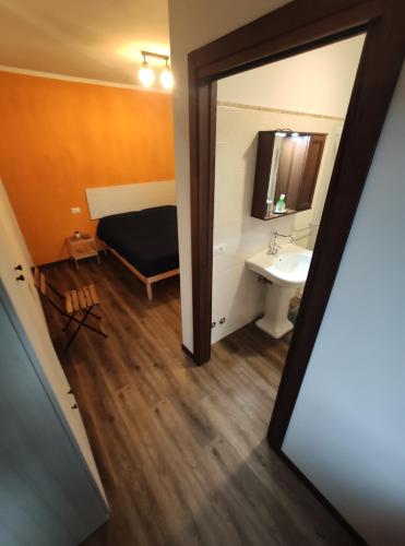 a bathroom with a bed and a sink and a mirror at B&B il Fienile in Cingoli