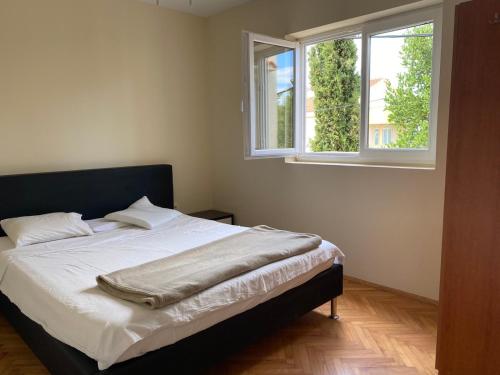 a bed in a bedroom with two windows at Villa Zoe Privlaka-Zadar in Privlaka