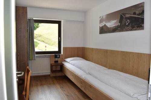 a bed in a room with a window at Haus Haberstock in Riezlern