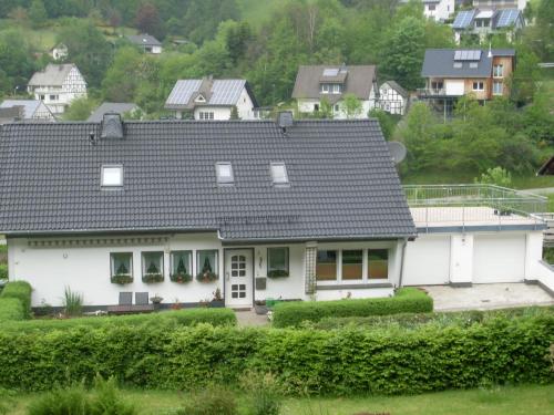 a white house with a gray roof at Ferienwohnung am Waldrand in Schmallenberg