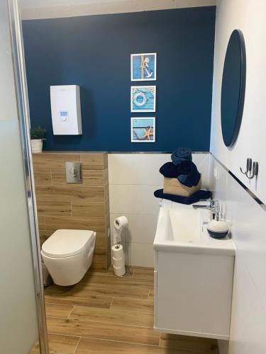 a bathroom with a white sink and a toilet at Domek Morze in Ustka