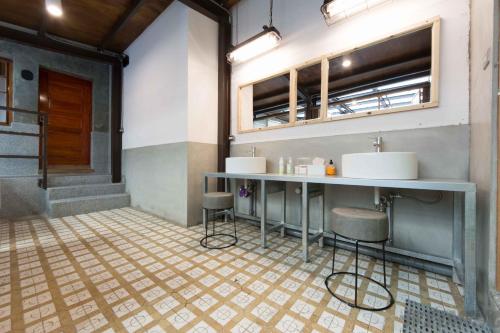 a bathroom with two sinks and a counter with stools at 158 Hostel in Tainan