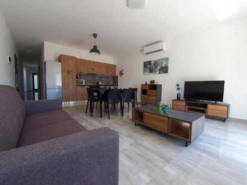 a living room with a couch and a tv and a table at F11 Modern and Bright Apartment in Malta in Msida