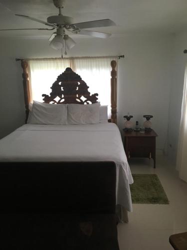 um quarto com uma cama grande e uma ventoinha de tecto em Treaysures em Santa Cruz