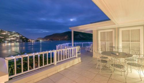 a balcony with a view of the ocean at night at Isola Bella Guest House in Knysna