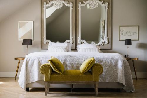 a bedroom with a bed with two mirrors and a yellow couch at Weranda Home in Sławica