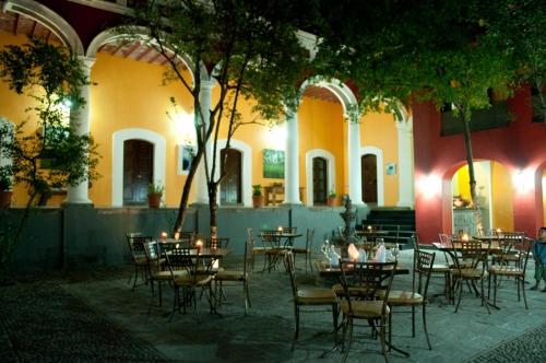 a group of tables and chairs in a courtyard at Hotel Boutique Hacienda del Gobernador in Colima