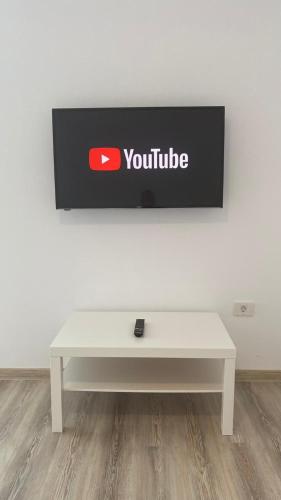 a white bench in front of a wall with a youtube sign at Blue Sky Transalpina in Săsciori