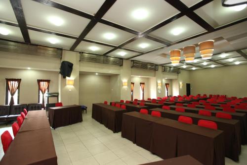a lecture hall with red chairs and tables and lights at Sanur Agung Hotel in Sanur