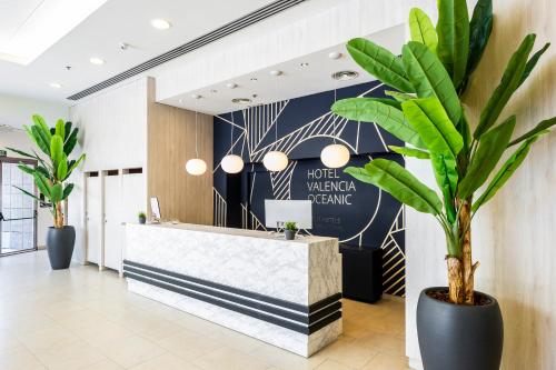 a lobby with a reception desk and a plant at Hotel Valencia Oceanic Affiliated by Meliá in Valencia