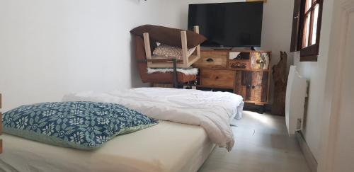 a bedroom with a bed and a tv and a chair at Maisonnette atypique en triplex au calme hyper-centre place du Ralliement in Angers