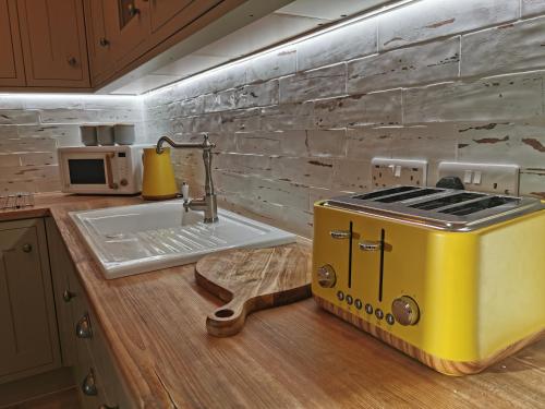 a kitchen with a yellow toaster on a counter at Seashell luxury apartment in Burnham on Sea