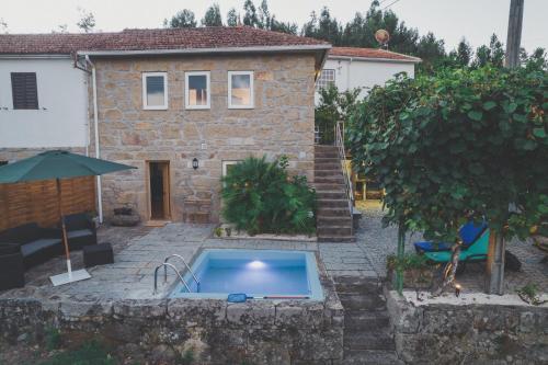 a house with a swimming pool in front of it at Quinta da Tia in Baiões