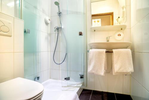 a bathroom with a shower and a toilet and a sink at Owl Hotel in Amsterdam