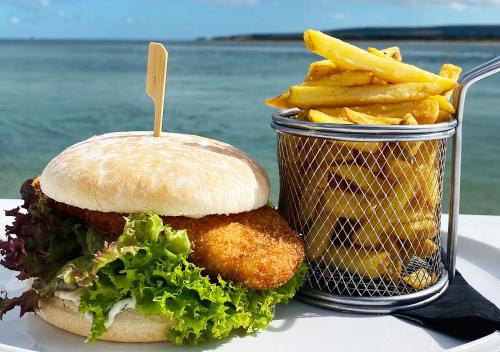 a sandwich and french fries next to a basket of fries at Haven Hotel in Poole