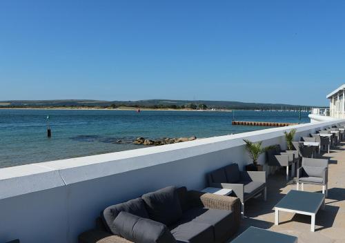 a row of chairs and couches next to the water at Haven Hotel in Poole