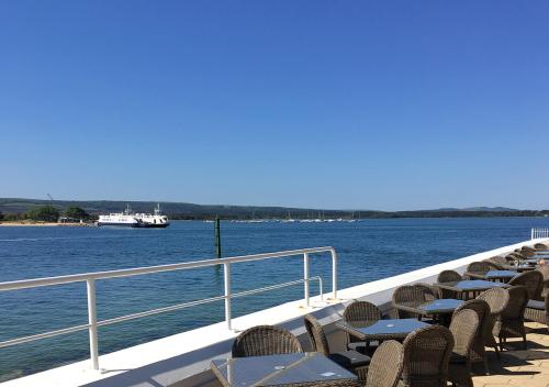 a group of tables and chairs on a boat on the water at Haven Hotel in Poole