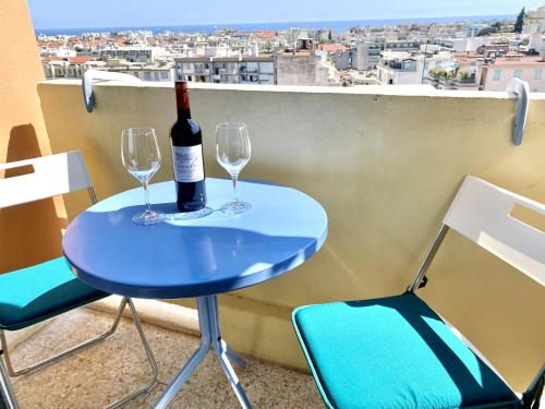 - une table bleue avec 2 verres et une bouteille de vin dans l'établissement Passy Azur AP4242 by Riviera Holiday Homes, à Nice