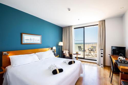 
a hotel room with a large bed and a large window at Hotel Valencia Oceanic Affiliated by Meliá in Valencia
