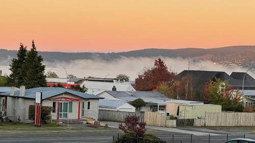 a group of houses in a city with fog in the background at Chantillys Motor Lodge in Taupo