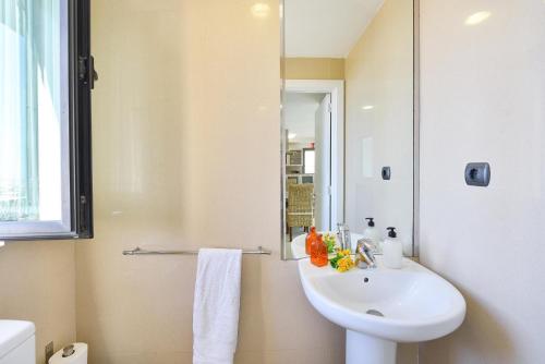 Baño blanco con lavabo y espejo en GreenSide 40 by VillaGranCanaria, en Maspalomas