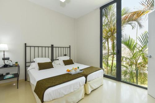 a bedroom with a large bed and a large window at GreenSide 40 by VillaGranCanaria in Maspalomas