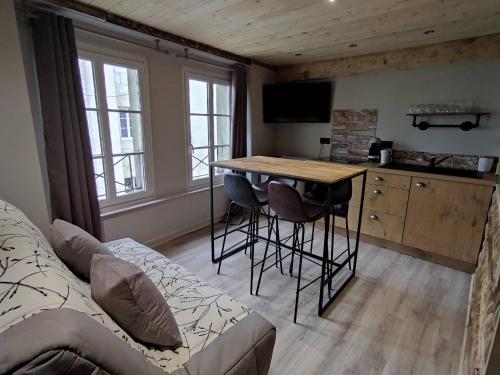 a kitchen with a table and chairs in a room at La Darbella - Style chalet de montagne in Dole