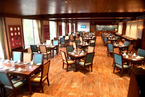 a dining room filled with tables and chairs at The Orchid Shimla in Shimla