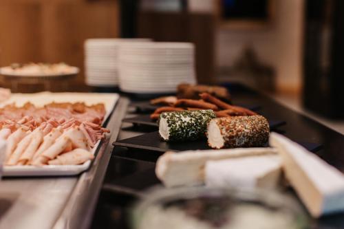 a table topped with different types of food on plates at Hotel Happy Filzmoos in Filzmoos
