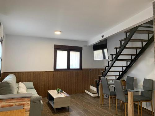 Una sala de estar con un sofá y una escalera. en La fuentenita, en Santa Cruz de Paniagua