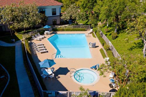 an overhead view of a swimming pool with chairs and umbrellas at Best Western Valencia/Six Flags Inn & Suites in Santa Clarita