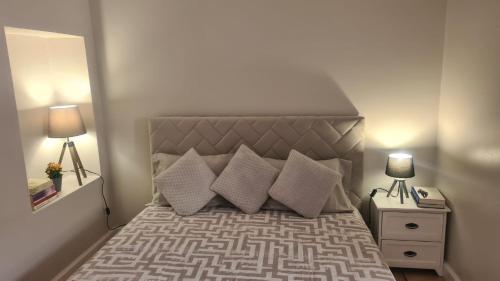 a bedroom with a bed with pillows and two lamps at Casa da Avó Duca in Machico