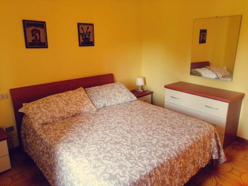 a bedroom with a bed and a dresser and a mirror at Elena Rooms in Campobasso