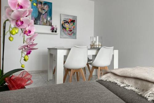 sypialnia ze stołem i 2 białymi krzesłami w obiekcie apartamento plaza del parque w mieście Villanueva de Arosa