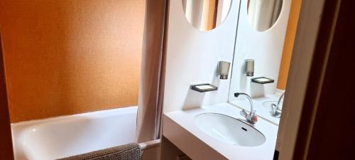 a bathroom with a sink and a bath tub at Appartement d'une chambre avec vue sur la ville balcon et wifi a Chamrousse in Chamrousse