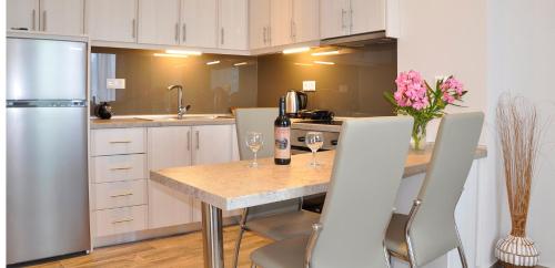a kitchen with a table with a bottle of wine and flowers at Dina's Paradise in Agios Gordios