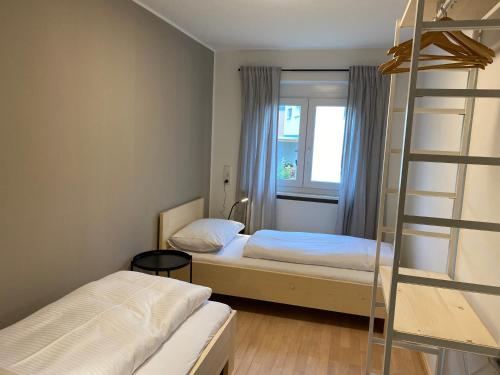 um pequeno quarto com duas camas e uma escada em WOHNUNG ERDGESCHOSS mit 3 Schlafzimmer in ruhiger Gegend em Mäder