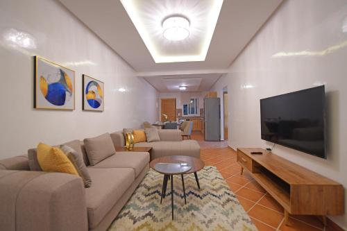 a living room with a couch and a flat screen tv at MY CASA - CABO NEGRO in Cabo Negro