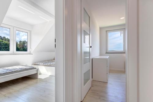 a white room with a bed and two windows at Compass House in Wisełka