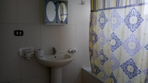 a bathroom with a sink and a shower curtain at Private Apartments in Caribe Dominicus solo adultos in Bayahibe