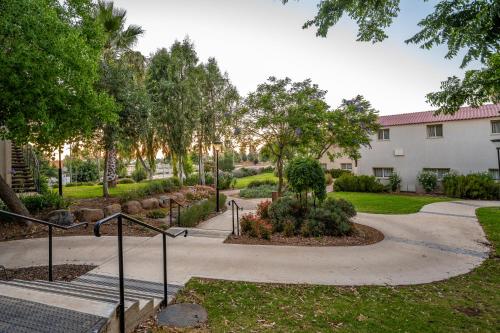a walkway in a park with trees and a building at Keshet Yehonatan Country Lodging in Keshet