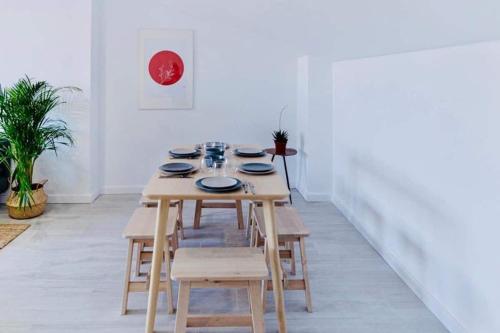 comedor con mesa de madera y sillas en Casa Mariel, en Málaga
