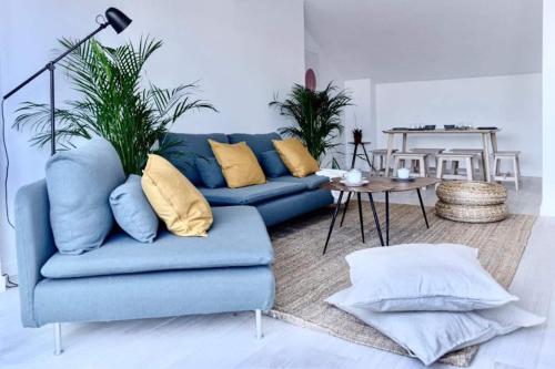 sala de estar con sofá azul y mesa en Casa Mariel, en Málaga