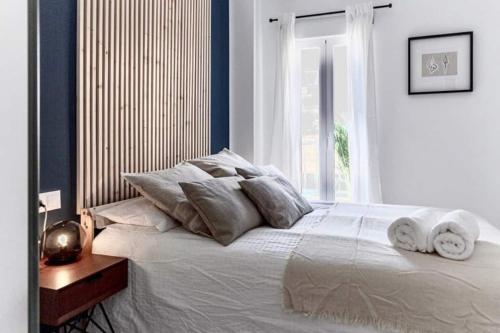 a bedroom with a large bed with pillows and a window at Casa Mariel in Málaga